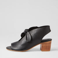 Black sandal with wooden heel on a light gray background