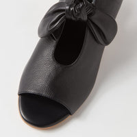 Black open-toe shoe with a bow on a white background
