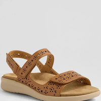 Brown sandal with cut-out design on a light gray background