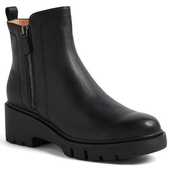 Black ankle boot with a zipper on a white background